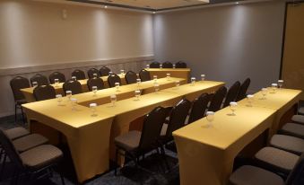 a conference room set up for a meeting , with chairs arranged in rows and a table in the center at Ayaartta Hotel Malioboro