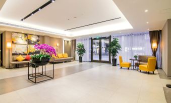A central area with large windows, chairs, and tables is the lobby at Home Inn Plus (Shanghai Bund Jinling East Road store)