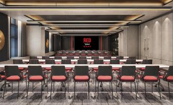 In a spacious room, rows of tables are arranged, with an empty space at the far end at Radisson RED Hotel Zhuhai Gongbei Port