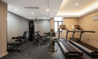 A spacious room contains multiple exercise machines, including an indoor treadmill positioned in the center at Maision New Century Hotel Keqiao Shaoxing