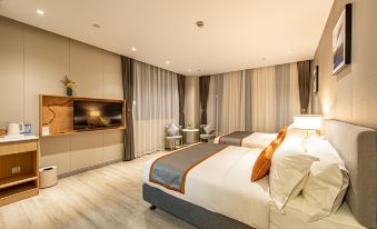The middle room features a large bed with modern furnishings and a flat-screen television at Shanghai JOYFUL YARD Hotel (Shanghai Pudong Airport Store)