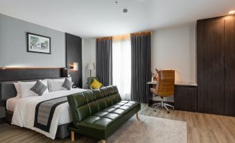 a modern hotel room with a green leather couch , wooden desk , and large window , as well as a desk and chair at SureStay Hotel by Best Western Vientiane