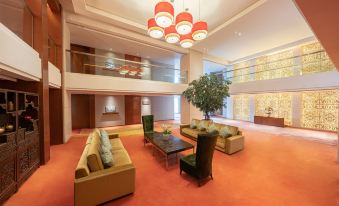 The modern-looking lobby features a spacious room with couches and chairs at The Eton Hotel Shanghai