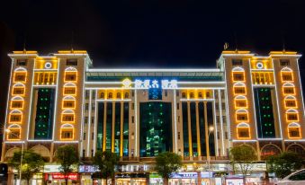 a large shopping mall with multiple levels and elevators , illuminated at night , surrounded by trees at Diamond Hotel