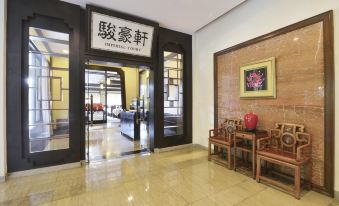 The entrance to a restaurant is adorned with tables and chairs, as well as an open area at Mission Hills Resorts Shenzhen