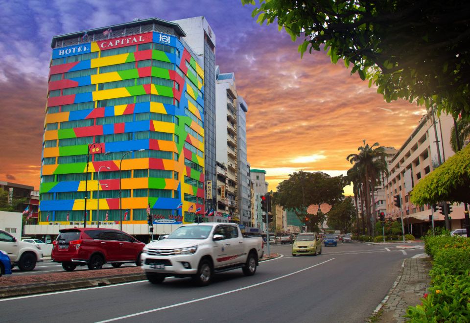 In a city filled with cars and buildings, there is an art installation located in front at Hotel Capital Kota Kinabalu