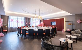 A spacious dining room is arranged with tables and chairs set for ten people at New Joyful Hotel