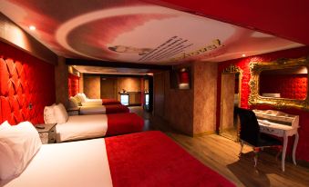 a room with three beds , two of which are red and the other two are white at Arthouse Hotel