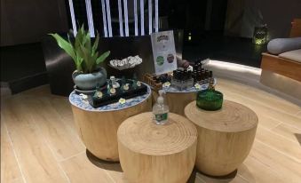 The coffee table is made from a variety of different types of wood and is accompanied by wooden stools at ICON LAB Hotel Shenzhen Futian