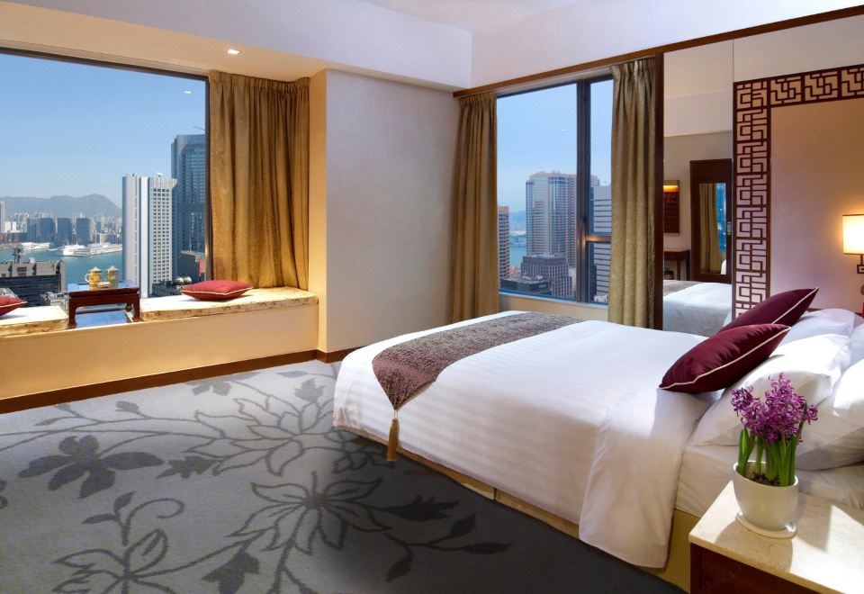 The hotel offers a bedroom with large windows and a balcony that overlooks the city at dusk at Lan Kwai Fong Hotel @ Kau U Fong