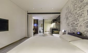 The modern-style home features a bedroom with a double bed and a large window that overlooks the living area at MUYI Hotel Hongqiao Hub Shanghai