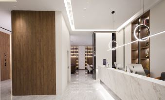 a modern , white - walled reception area with a wooden panelled wall and a white marble counter at Suisse Apartment Hotel Suzhou Jinji Lake Expo Center
