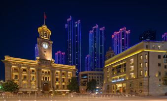 In a city at night, the lights illuminate the buildings, including one prominent structure at Grand Madison Wuhan Hankou on the Bund
