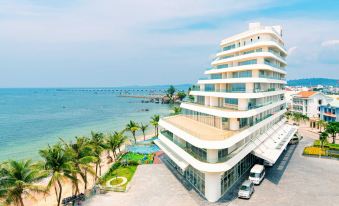 a large , modern hotel complex with multiple floors and balconies overlooking the ocean , surrounded by palm trees at Seashells Phu Quoc Hotel & Spa