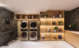 A room with shelves and washing machines in the laundry area, alongside an open door at Guangzhou Zhujiang New Town Ausotel Smart Hotel, Canton Fair Free Shuttle