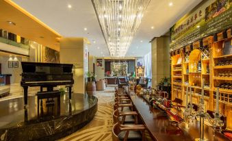 The restaurant is located in the center, alongside an open concept living room, and has tables and chairs at Maision New Century Hotel Keqiao Shaoxing