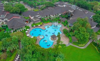 An aerial view reveals a pool and water park at a spacious resort or hotel that offers multiple amenities at Mission Hills Resorts Shenzhen