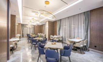 a modern dining room with multiple tables and chairs arranged for a group of people to enjoy a meal together at Suisse Apartment Hotel Suzhou Jinji Lake Expo Center
