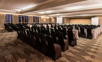 a large conference room with rows of chairs arranged in a semicircle , ready for a meeting at Newport Beachside Hotel & Resort