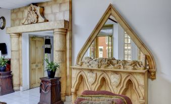 a living room with a couch , a chair , and a mirror on the wall at Empire Hotel