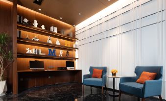 The room is decorated with modern wood and includes two chairs and a table placed alongside the wall at Hampton by Hilton Yiwu International Trade Market