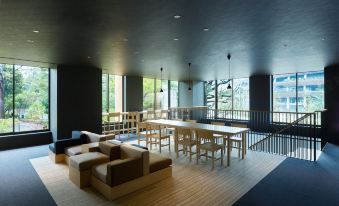 a large , modern living room with wooden floors and walls , featuring multiple couches and tables at Mitsui Garden Hotel Jingugaien Tokyo Premier