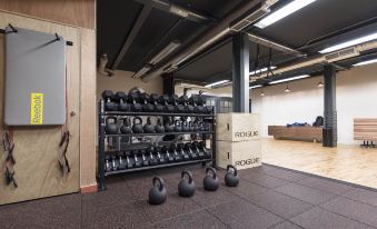a gym with a variety of kettlebells , mats , and a large rack filled with dumbbells at Cheval Old Town Chambers