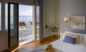 a bedroom with a large window overlooking the ocean , and a bed in the room at Hotel Punta Nord Est