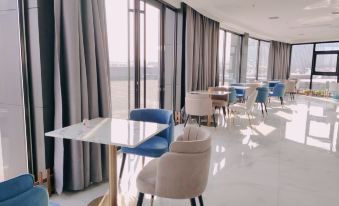 a modern , open - concept dining area with blue and beige chairs arranged around a table at Xuzhou Bo'an Hotel (University of Mining and Technology City Subway Station)