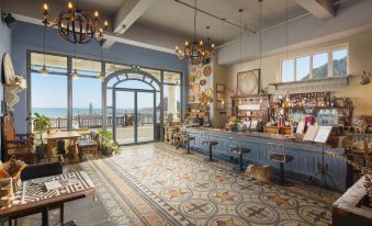 a modern cafe with wooden floors , large windows offering views of the sea , and stylish furniture at Amble Hotel