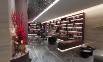 a modern , well - lit bookstore with a long wooden bookshelf and a coffee table in the center at Guangzhou Hotel