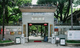 In front of the temple, there is an entrance featuring large wooden doors and statues on either side at Foshan Lushan Hotel (Shunde Qinghuiyuan)
