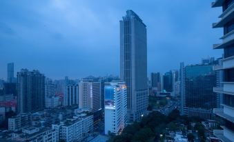The cityscape is adorned with towering buildings and skyscrapers, creating a mesmerizing sight during dusk or nighttime at Moka Apartment (Guangzhou CUHK Cancer Hospital Taojin Subway Station)