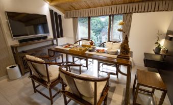 A spacious room furnished with wooden furniture, including a dining table and an area rug at West Lake Teavilla
