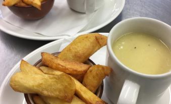 a plate of deep - fried food and a bowl of dipping sauce on a dining table at The Farm Burscough