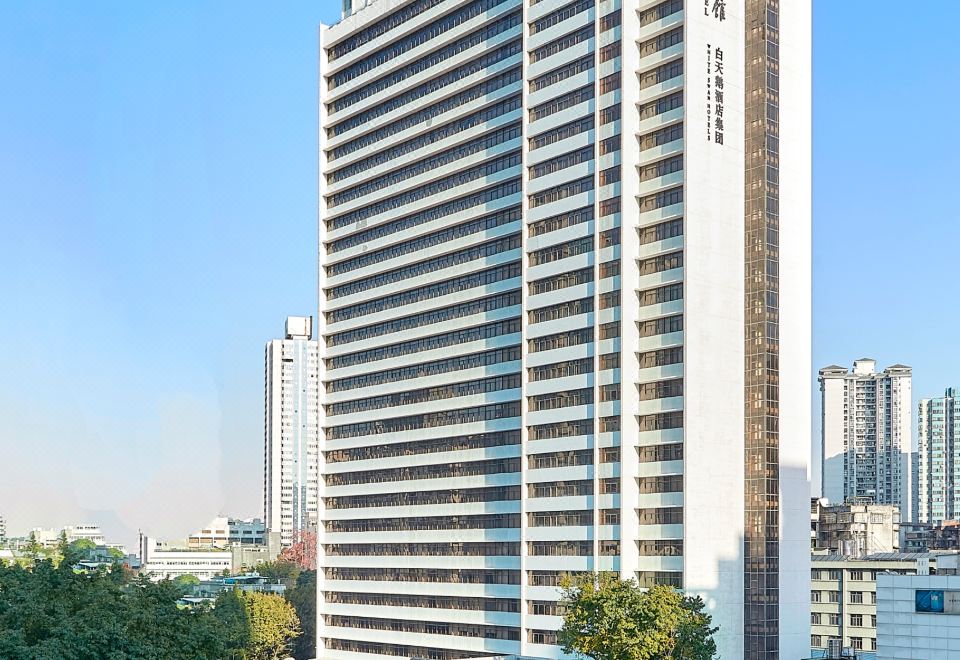 A large office tower is surrounded by other buildings in a central location at Baiyun Hotel