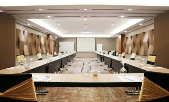 a large conference room with multiple rows of chairs arranged in a semicircle around a long table at Oakwood Hotel and Residence Kuala Lumpur