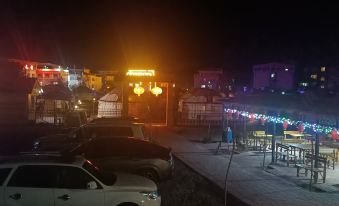 At an outdoor restaurant in Japan, there is a night view of cars parked outside on the street at Colorful Danxia Yimi Sunshine Inn
