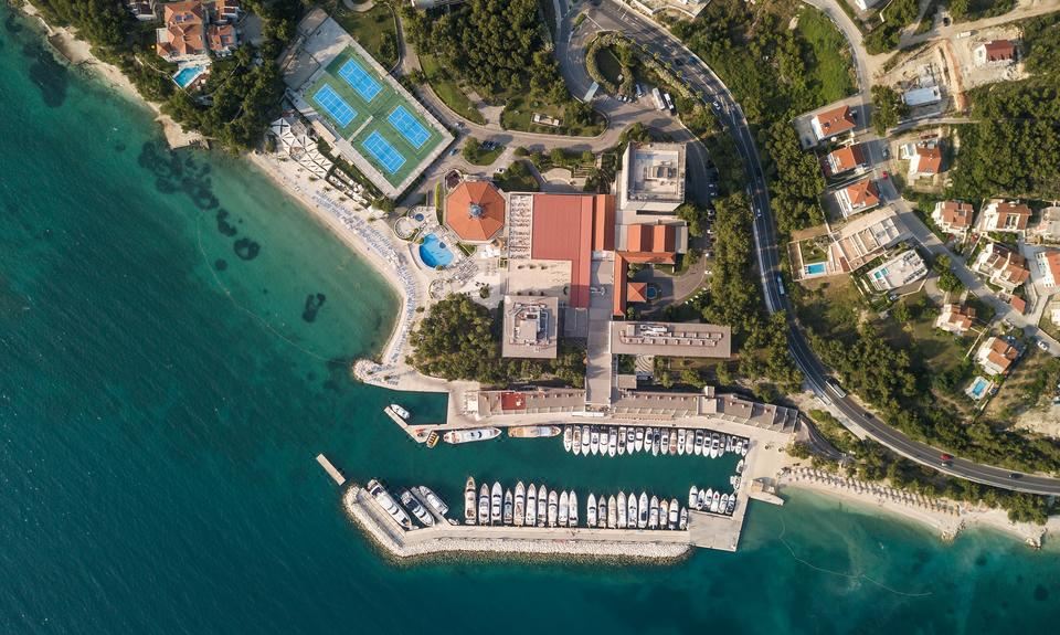 aerial view of a marina with multiple boats docked , including sailboats and yachts , near the water 's edge at Le Meridien Lav Split