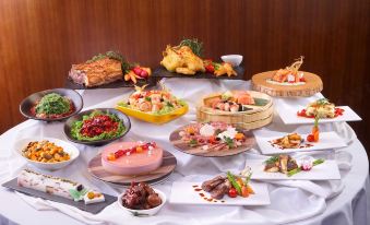A table at an oriental restaurant is filled with numerous dishes and plates at The Harbourview-Chinese YMCA of Hong Kong