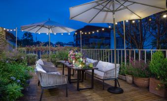 At night in the downtown area, there is a patio with tables and chairs under an umbrella at Peking Yard  Boutique Hotel