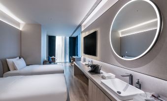 The modern bedroom features double beds, a sink, and a large mirror in the center at Crystal Orange Shenzhen Nanshan Science and Technology Park Hotel