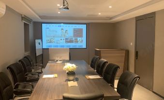The conference room is equipped with a large wall-mounted screen and a long table that can accommodate up to six people at Mumian Hotel (Guangzhou Baiyun International Airport)