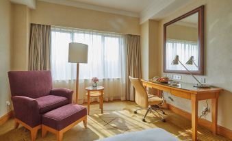 A room with large windows, a bed, and a desk also includes an armoire at Radisson Collection Hotel, Yangtze Shanghai