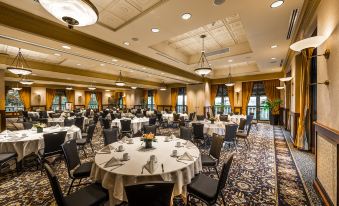 a large , well - lit banquet hall with multiple round tables and chairs arranged for a formal event at Hotel Grand Pacific