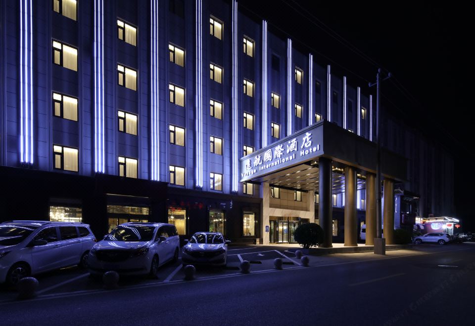 The building housing a hotel is illuminated with neon lights during the night at VOYAGE INTERNATIONAL HOTEL