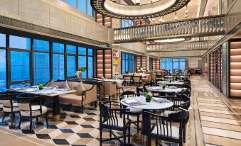 The restaurant features large windows, tables in the middle, and an open concept floor at Kasion K Hotel Yiwu