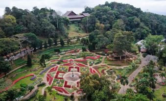 an aerial view of a lush green garden with a gazebo in the middle , surrounded by trees and flowers at DoiTung Lodge