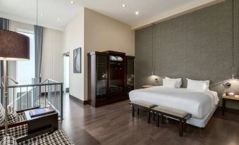 a modern bedroom with hardwood floors , a large bed , and a tv mounted on the wall at NH Den Haag