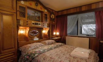 a cozy bedroom with a large bed , wooden headboard , and two nightstands on either side of the bed at Karelia Alpine Lodge